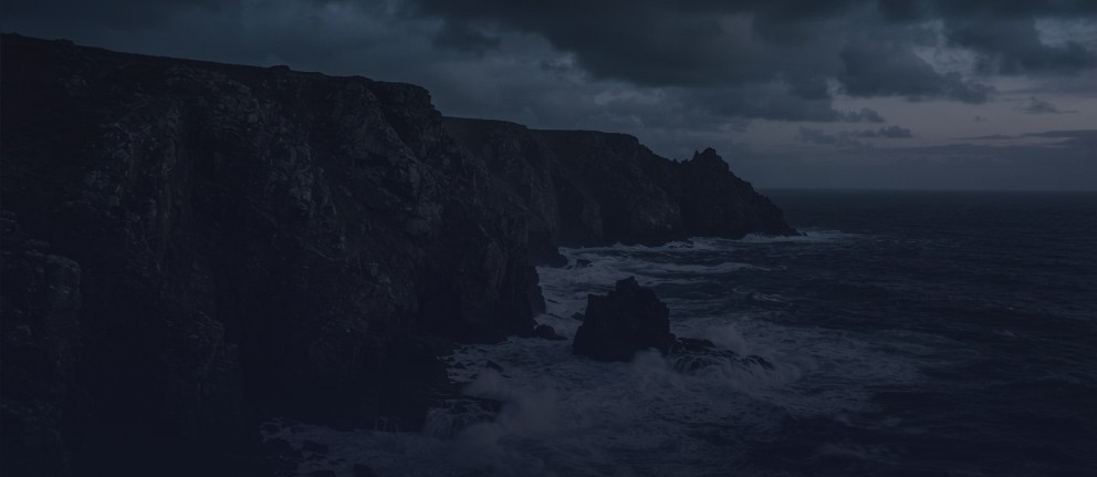 Dark sea cliffs under a stormy sky