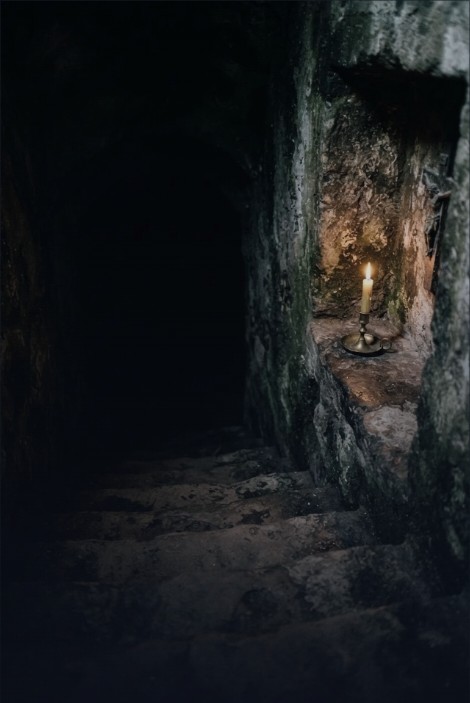 A candle burning in a stone cave passage